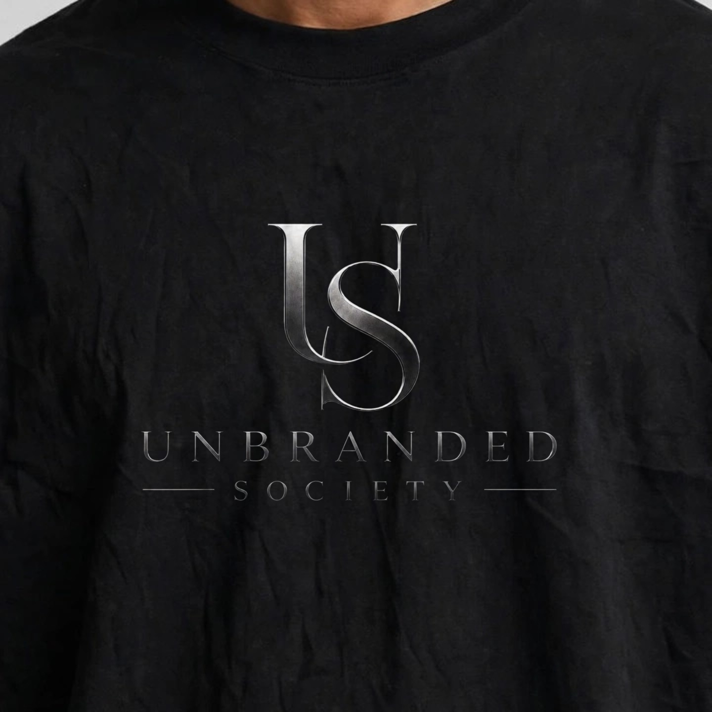 Close detail of the Unbranded Society logo on the front of the oversized T-shirt.